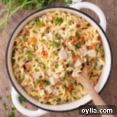 Close up photo of a pot of Chicken Pot Pie Pasta with a spoon in it