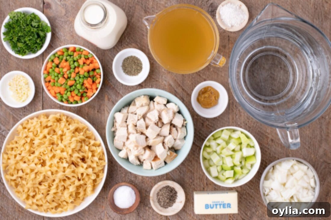 Fresh ingredients laid out for making Chicken Pot Pie Pasta: chicken, egg noodles, vegetables, and seasonings.