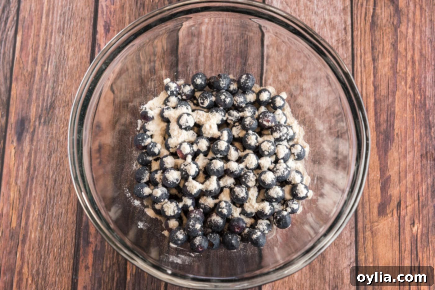 Blueberries lightly tossed in flour in a small bowl, ready for baking.