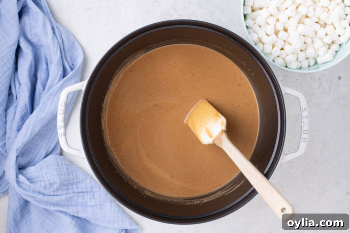 melted peanut butter in a pot with a rubber spatula