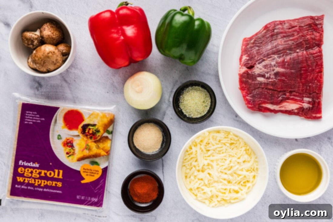 Ingredients for Philly Cheesesteak Egg Rolls laid out on a cutting board
