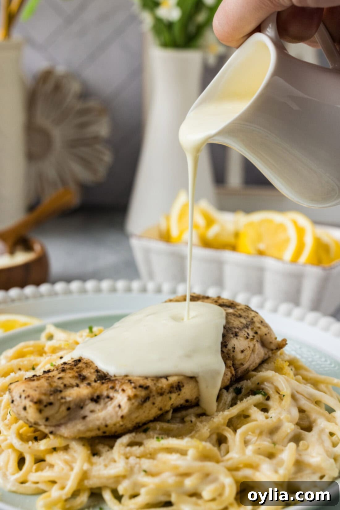 Lemon Cream Sauce being poured over a chicken breast