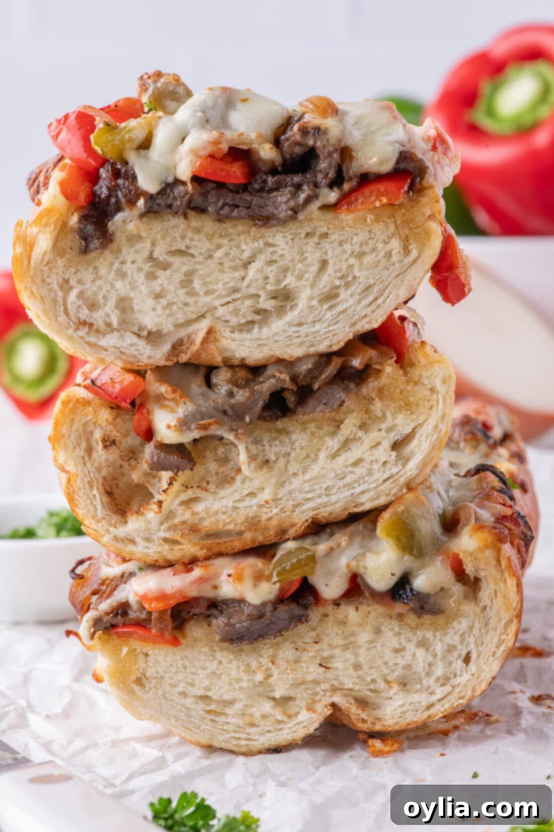 Stack of Philly Cheesesteak Cheesy Bread slices, showcasing melted cheese, steak, and vegetables on crispy bread.