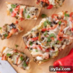 Slices of Philly Cheesesteak Cheesy Bread on a wooden cutting board, garnished with fresh parsley.