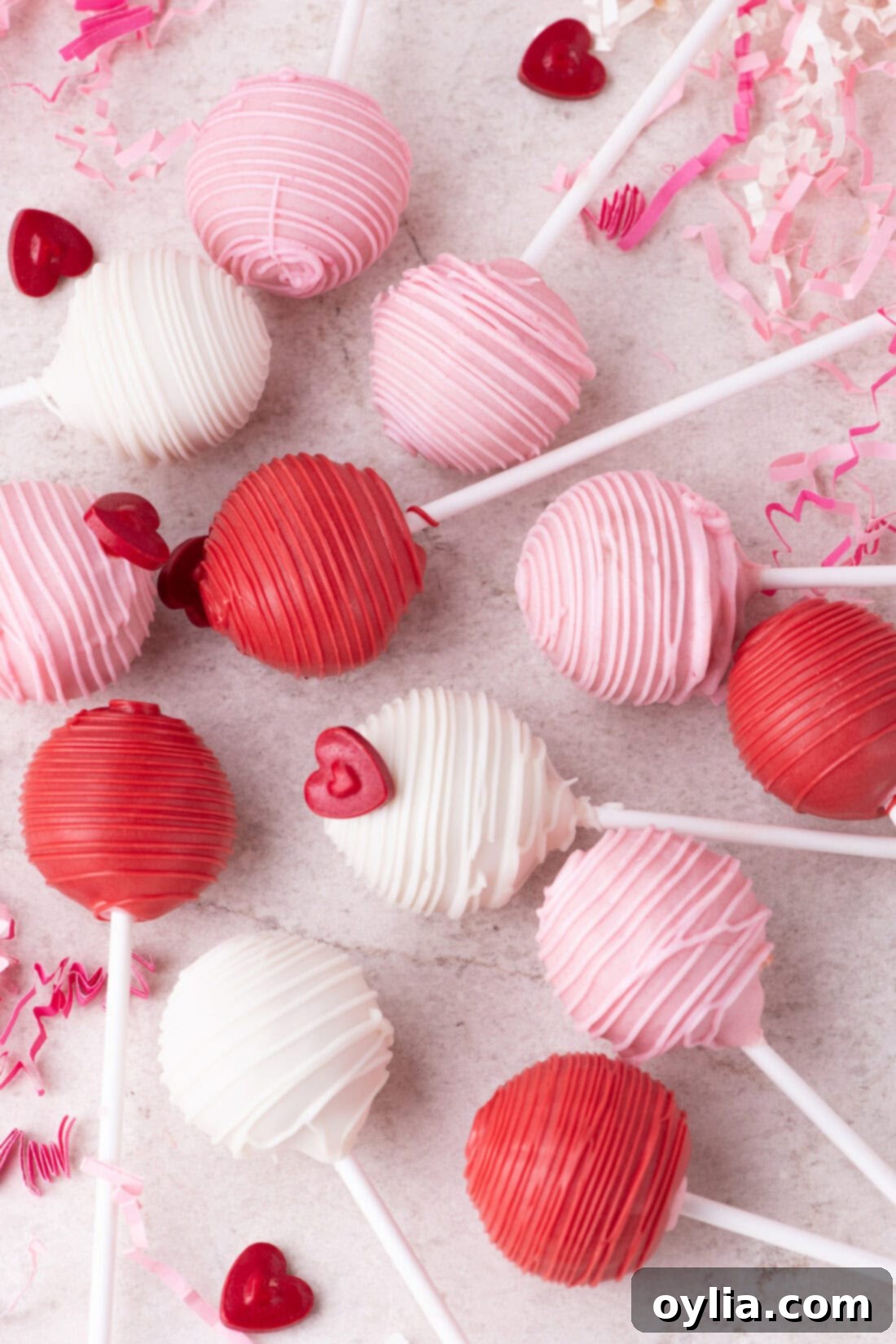 Love-Filled Valentine Cake Pops 2 Valentine Cake Pops elegantly arranged on a rustic wooden table, showcasing their delightful red, white, and pink coatings and festive sprinkles, perfect for a romantic celebration.