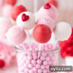 Love-Filled Valentine Cake Pops 13 Valentine Cake Pops resting in a clear glass container, showcasing their vibrant colors and festive presentation.