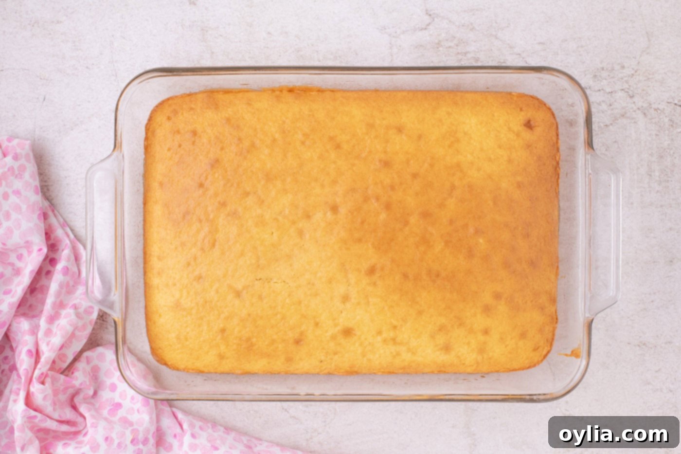 freshly baked yellow cake in a 9x13 inch dish, cooling