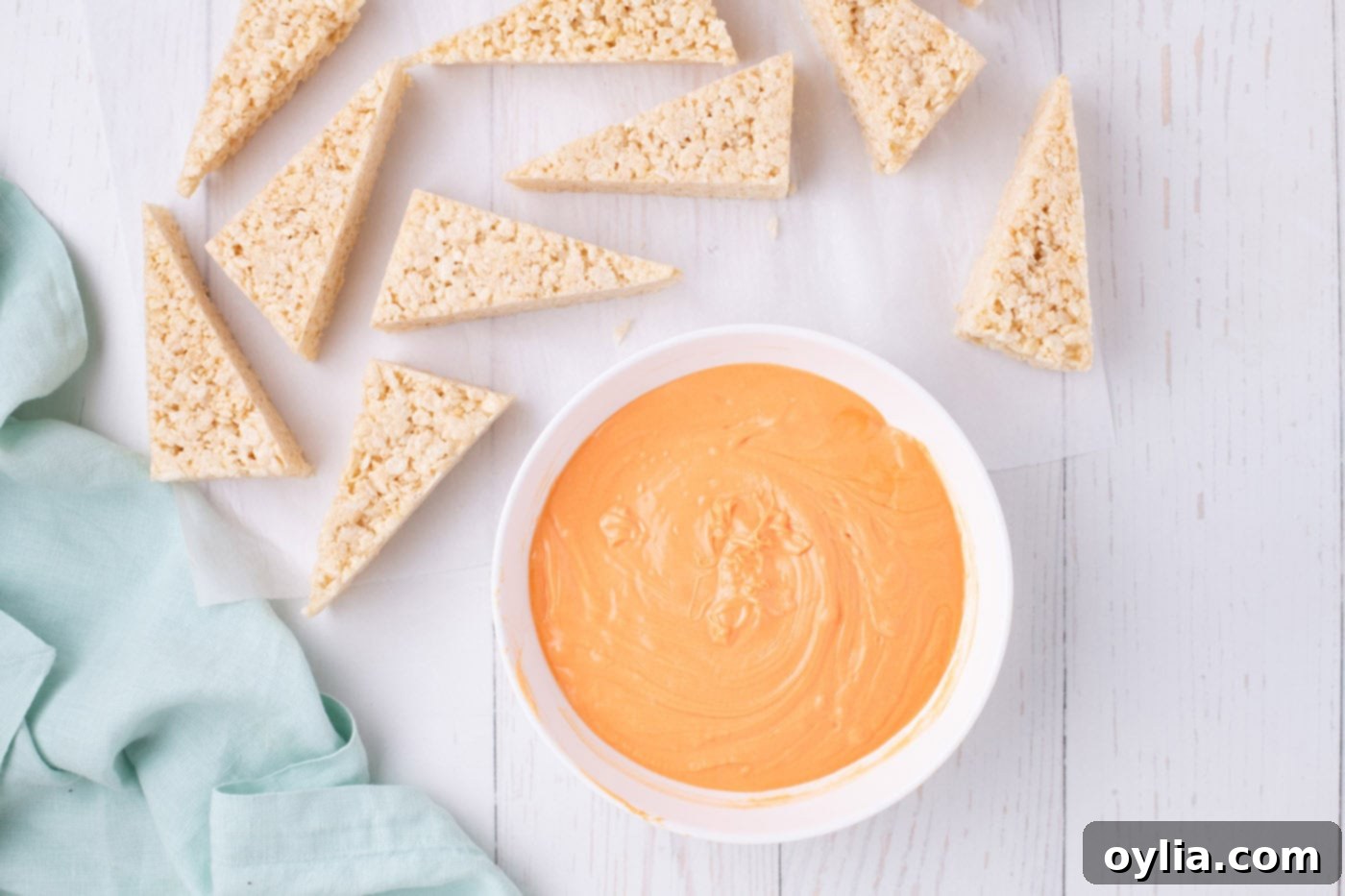 melted orange chocolate next to rice krispie triangles