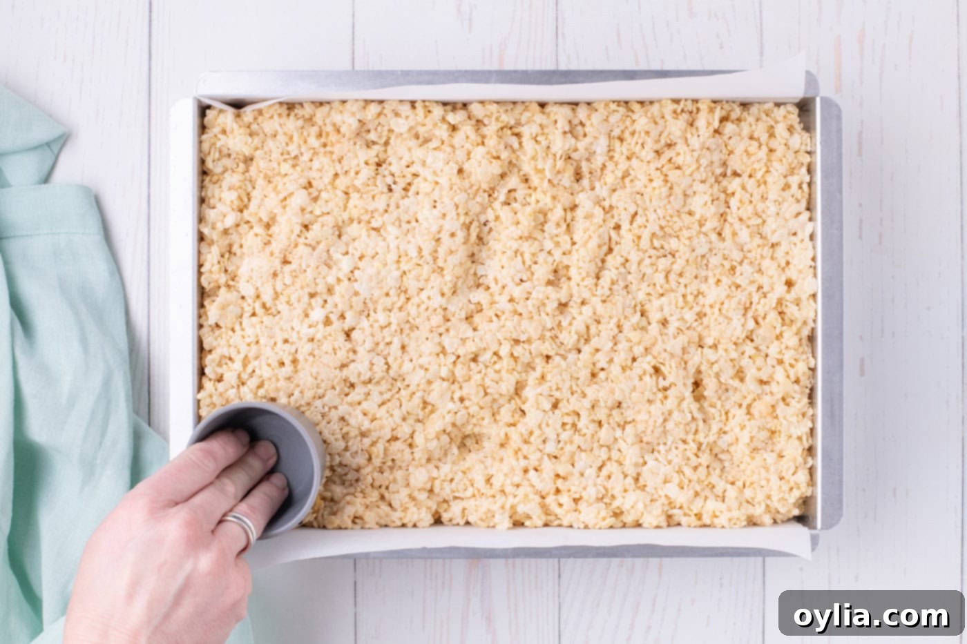 pressing rice krispie treats into baking dish