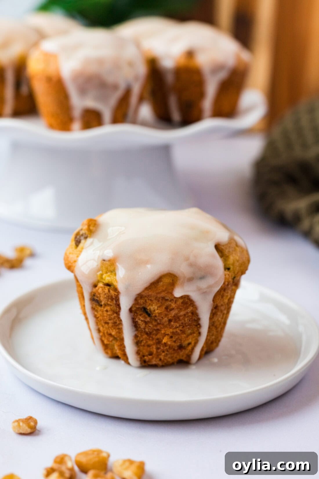 Zucchini Muffins in a Flash 2 Shortcut Zucchini Muffins arranged on a white plate with more muffins in the background