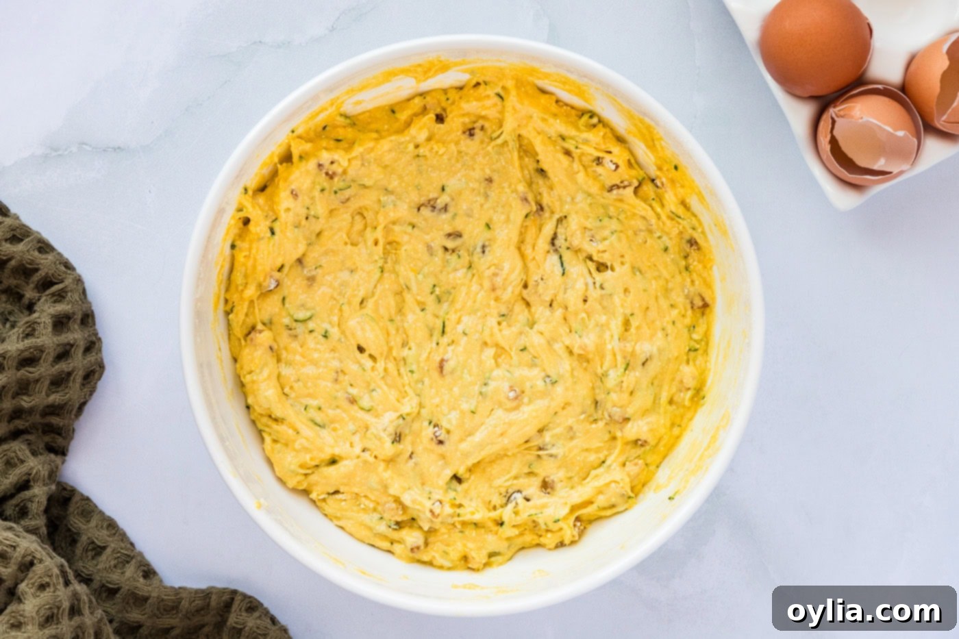 Zucchini muffin batter in a mixing bowl, showing the consistency