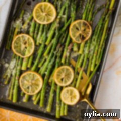 Sheet pan of Lemon Asparagus with a spatula in it