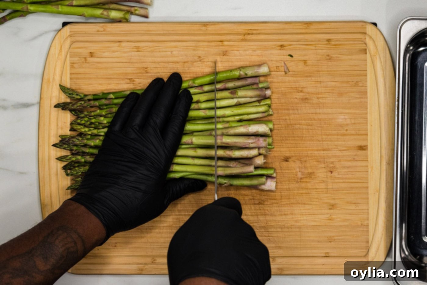 knife cutting woody ends off asparagus