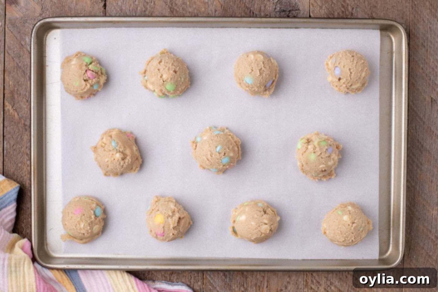 Mounds of cookie dough neatly placed on a baking sheet, ready for chilling.