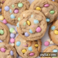 Close up photo of a pile of Easter M&M Cookies, showing their soft texture and colorful candies.