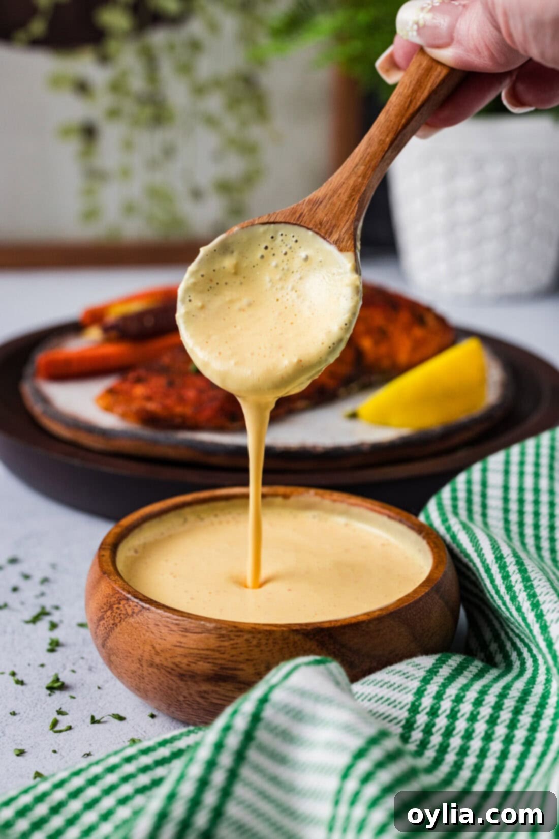 Spoon pouring creamy, vibrant homemade Remoulade Sauce into a small white bowl, ready for dipping