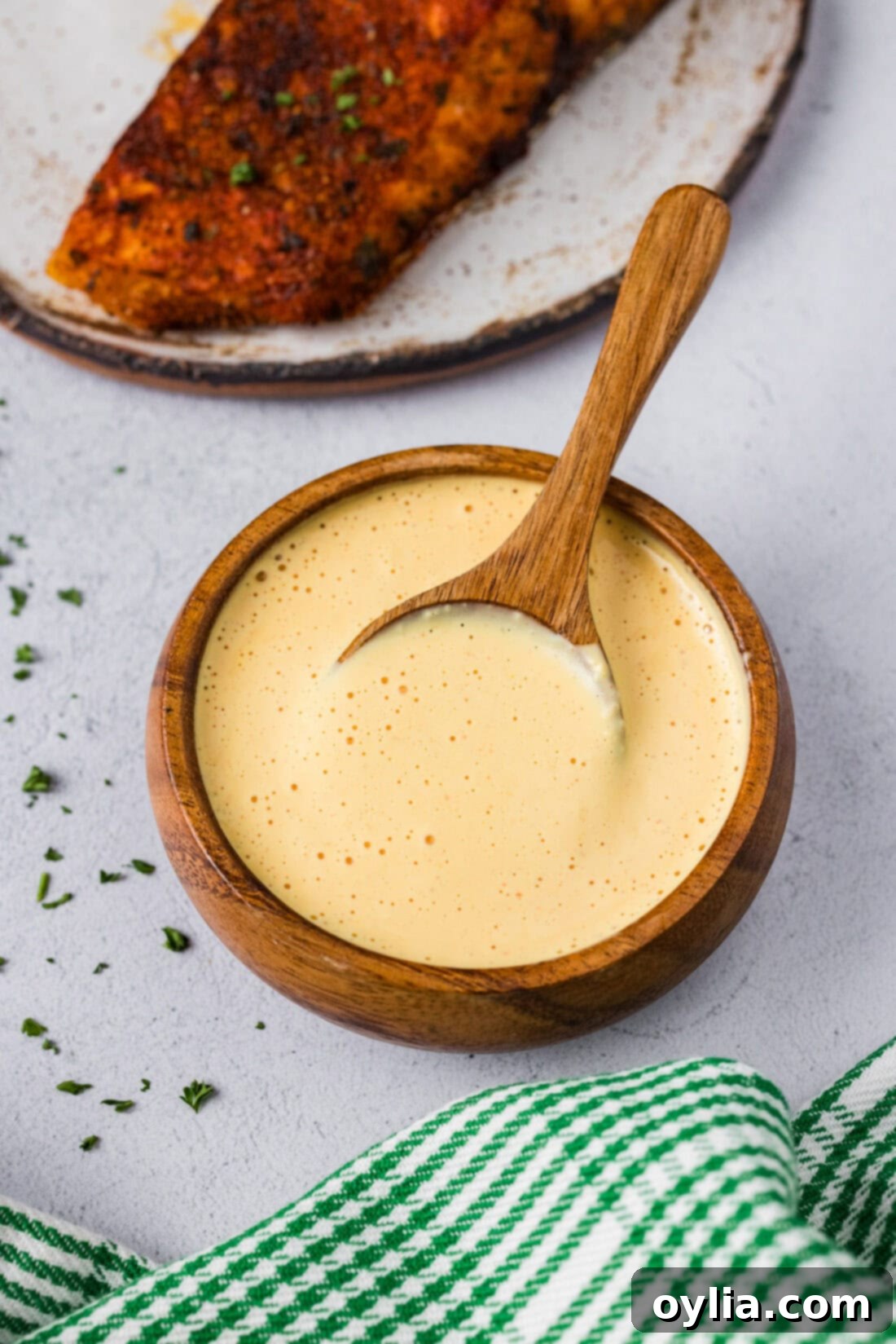 Close-up of a beautifully presented bowl of creamy homemade remoulade sauce with a silver spoon resting in it, ready to be enjoyed