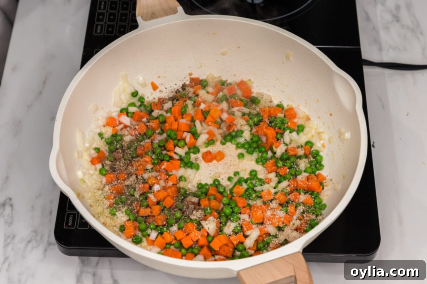 carrots, peas, and onion in a skillet with oil and garlic