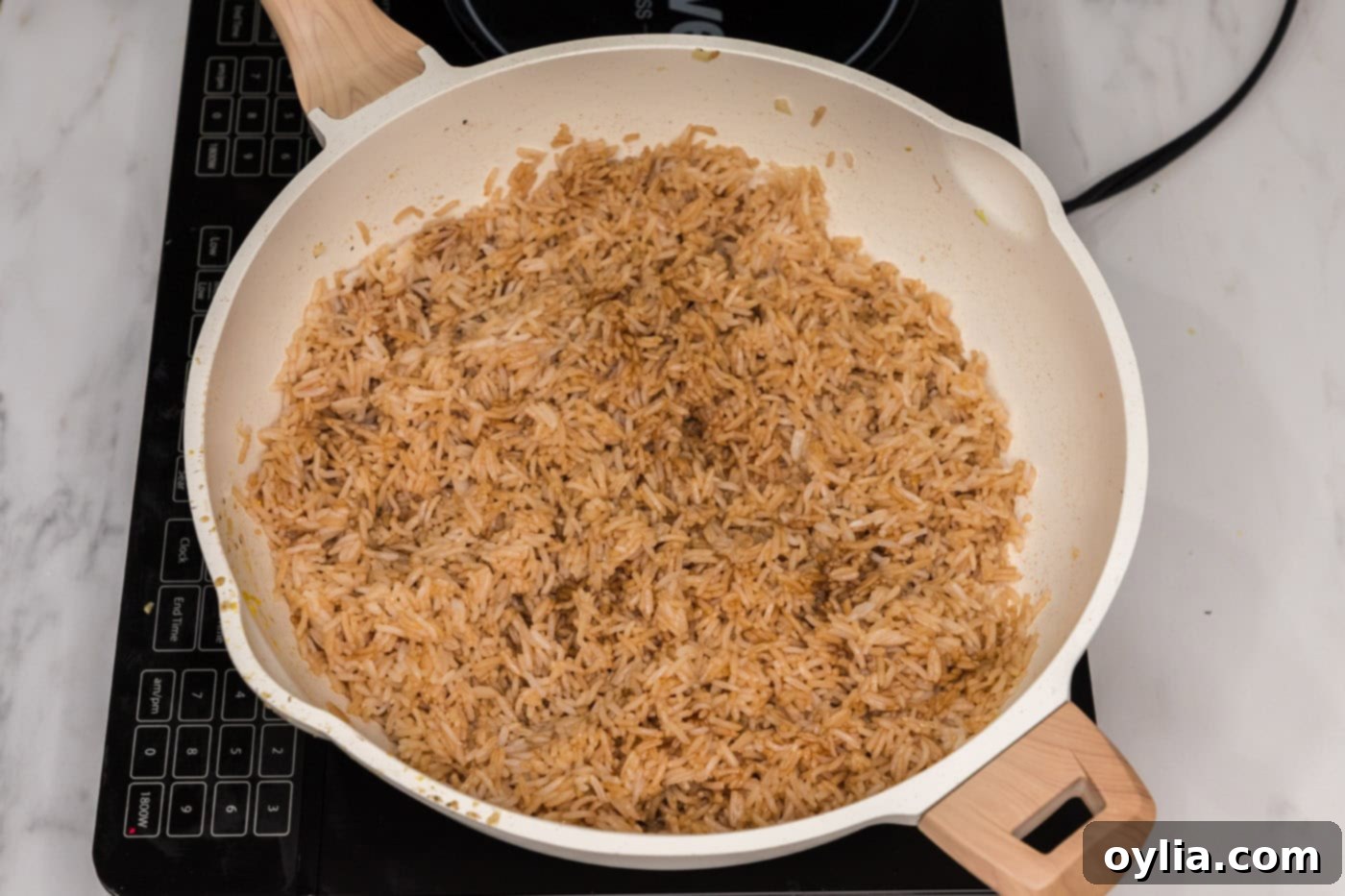 soy sauce and oyster sauce mixed with rice in a skillet