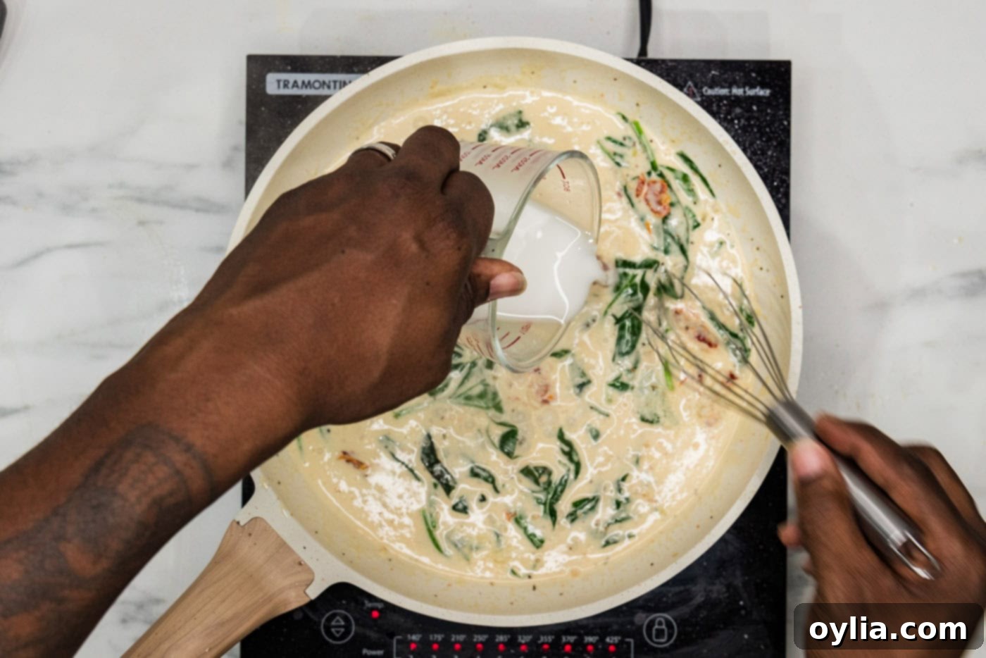 Cornstarch slurry being poured into the skillet with the creamy sauce, ready to thicken.