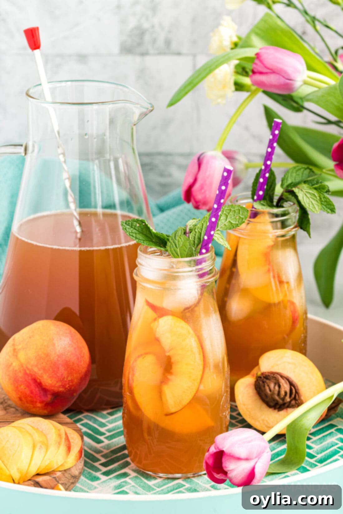 Two bottles of homemade peach iced tea, ready to be served
