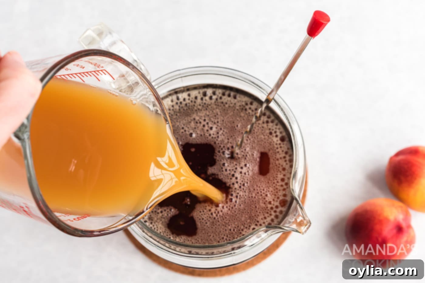 Pouring peach nectar into the pitcher of sweetened tea