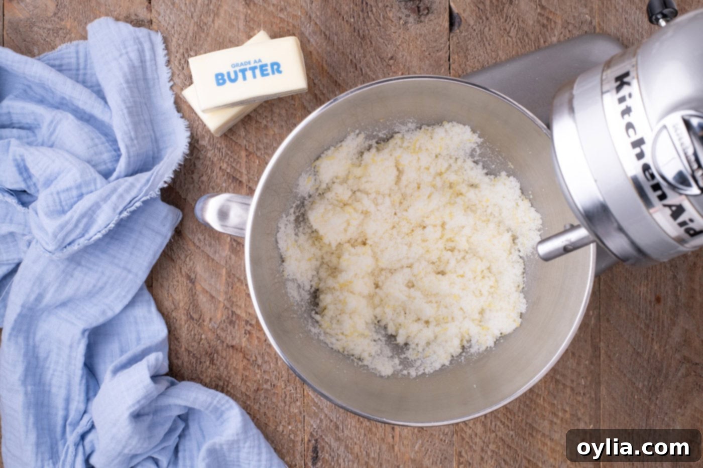Granulated sugar and lemon zest mixture being prepared in a stand mixer bowl