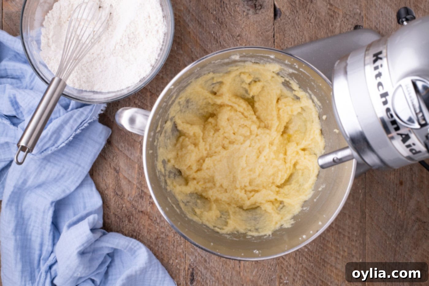 Butter, eggs, and sugar mixture being beaten in a stand mixer bowl