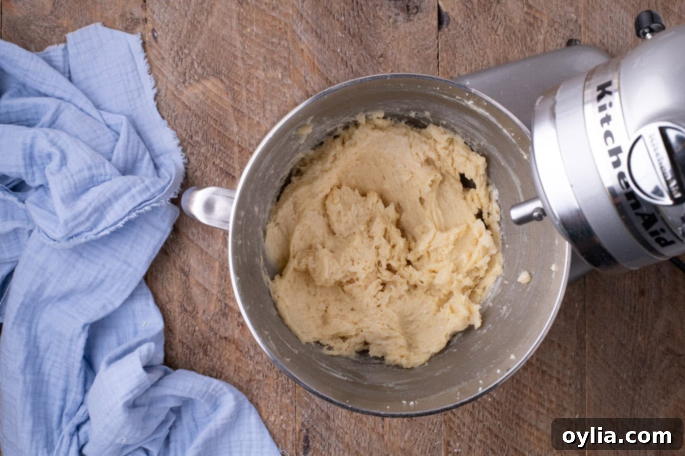 Partially mixed lemon cake batter mixture in a stand mixer bowl