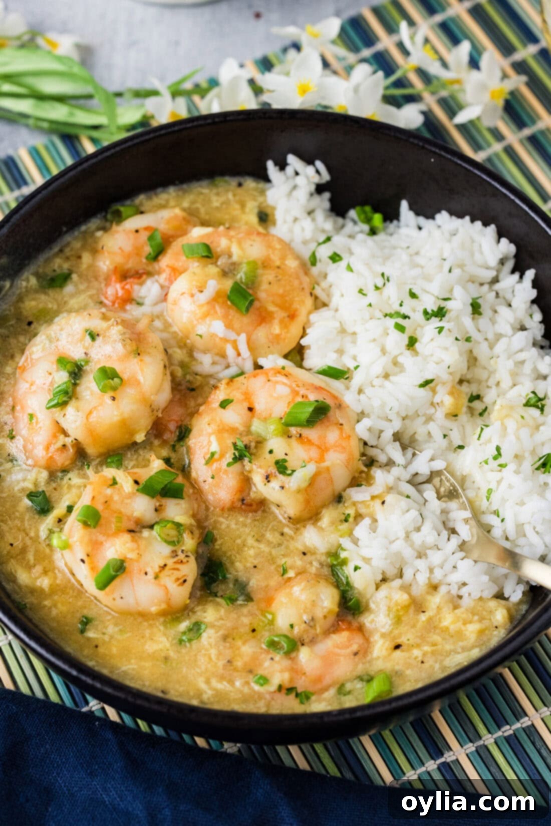 Close up photo of a bowl of rice and Shrimp with Lobster Sauce, highlighting the succulent shrimp and creamy sauce