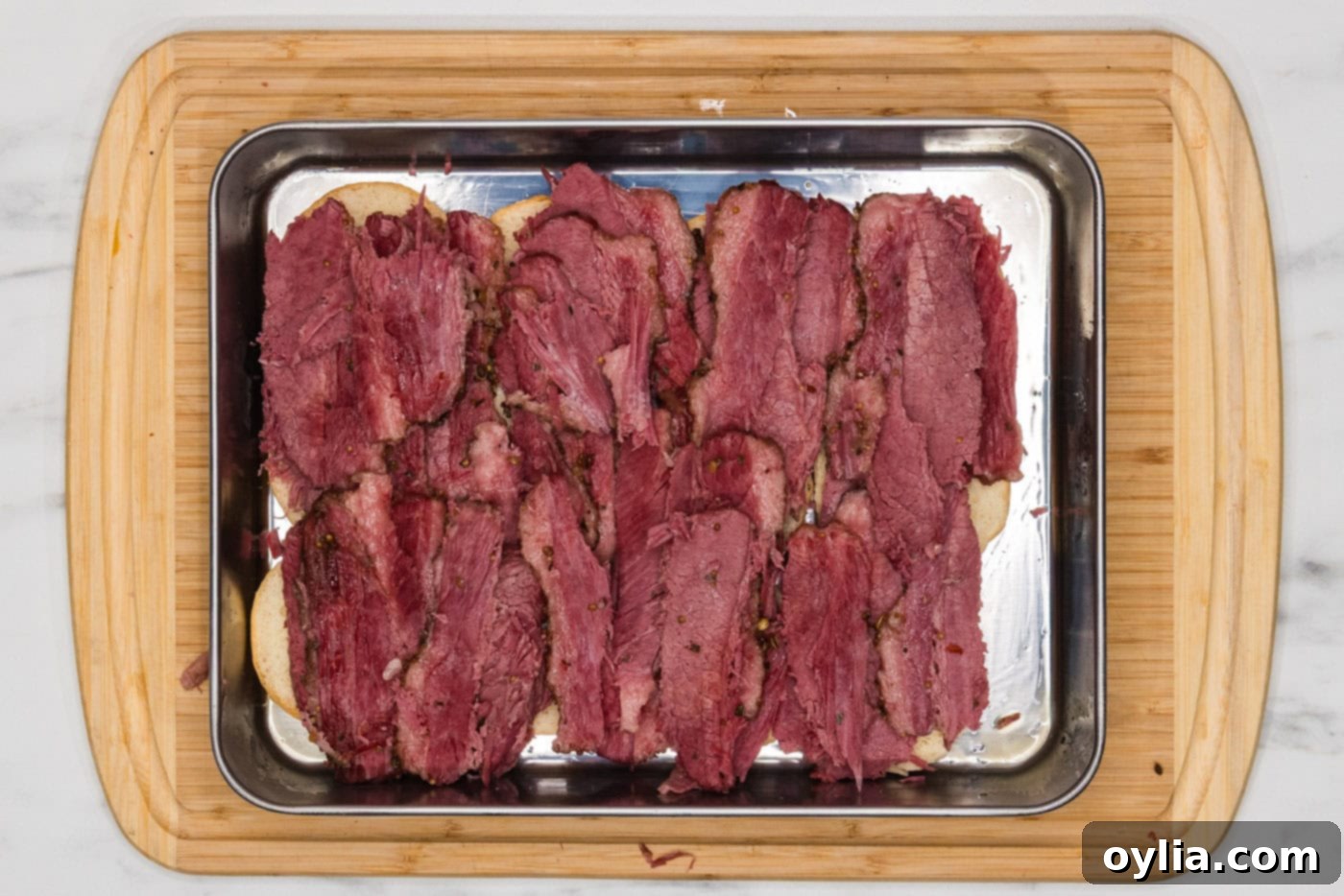 Corned beef layered neatly on top of the bottom slider buns