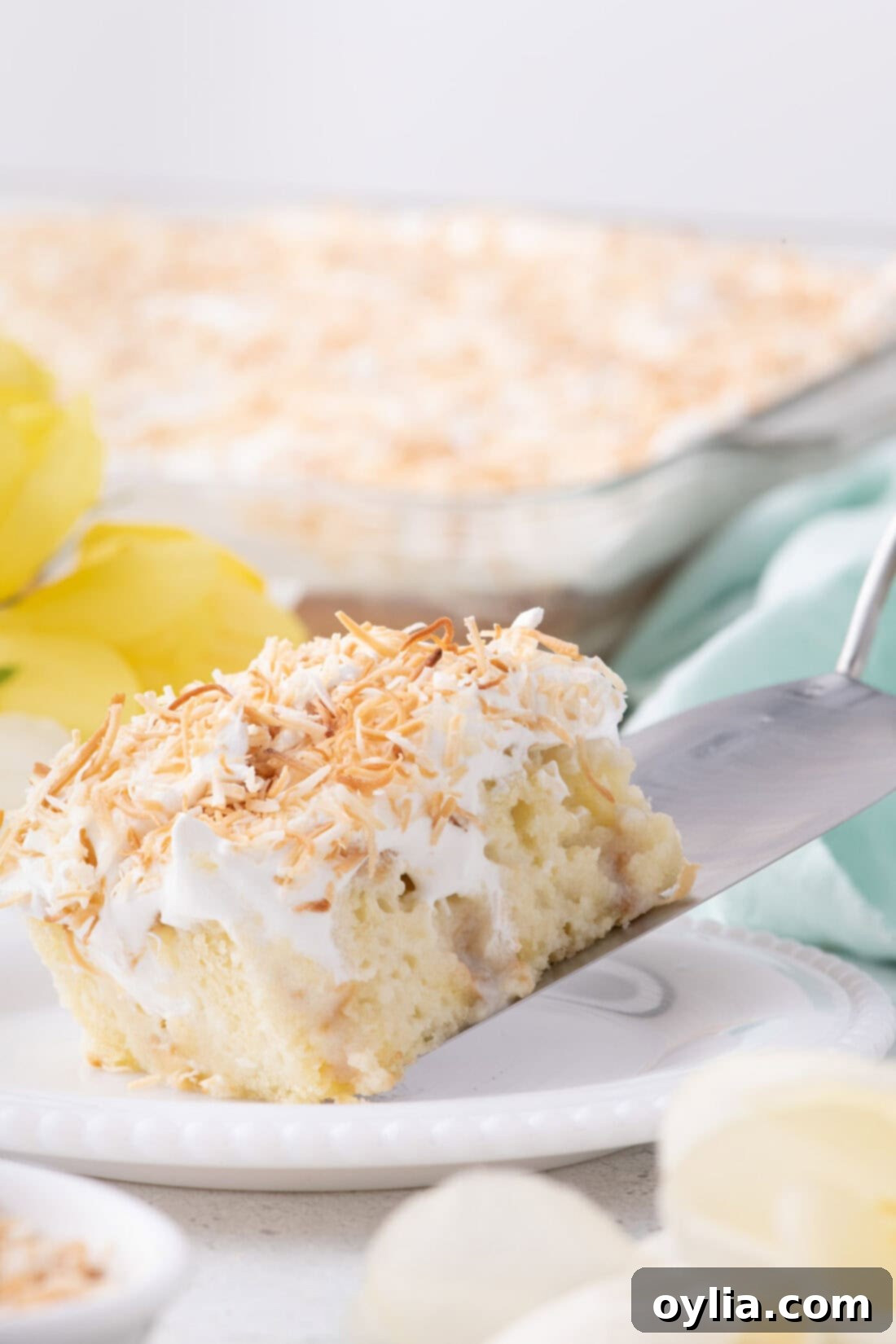 Slice of Coconut Poke Cake being served onto a plate