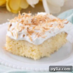 Close up photo of a slice of Coconut Poke Cake