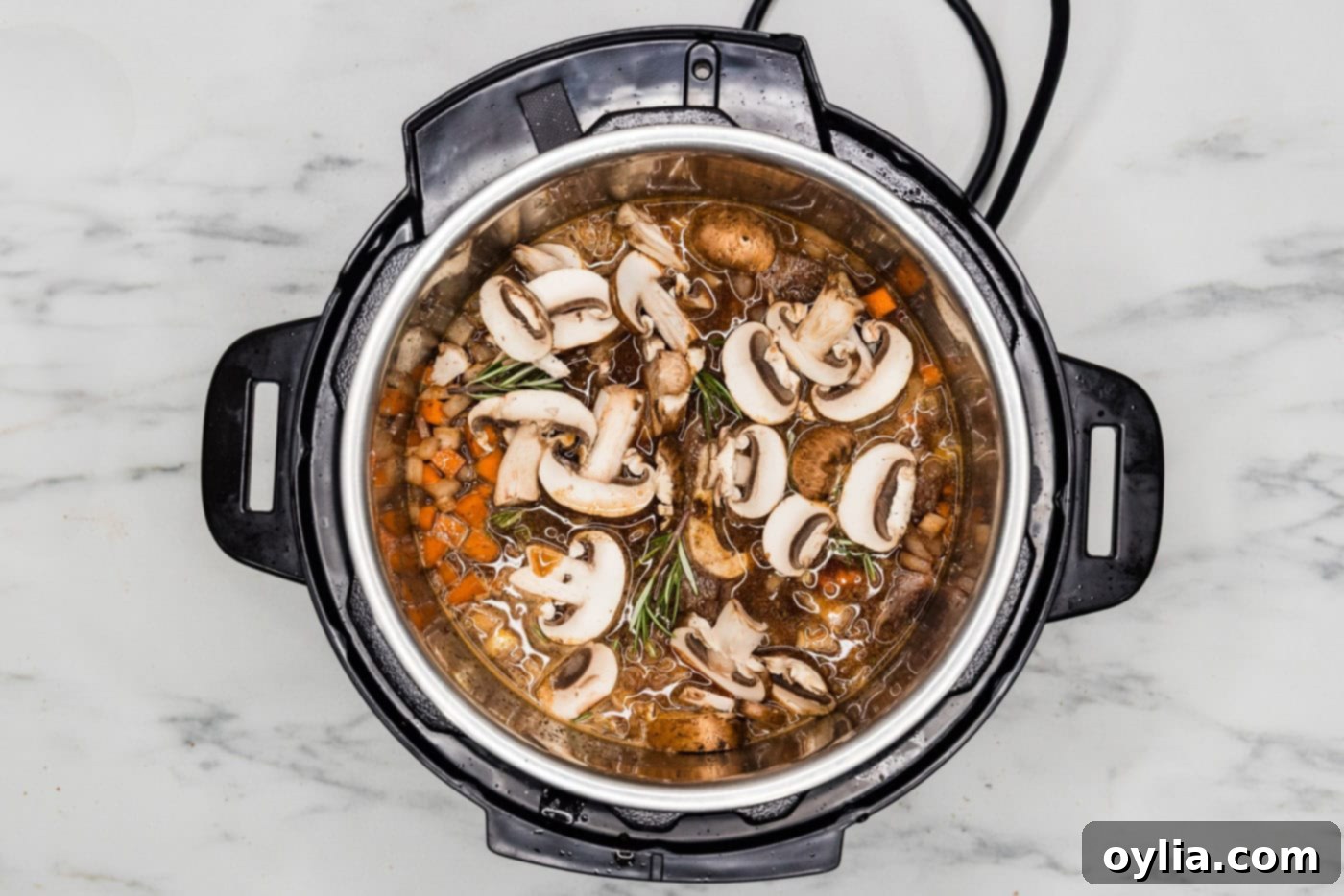 Sliced mushrooms and fresh rosemary sprigs added to beef shanks and vegetables in the Instant Pot.
