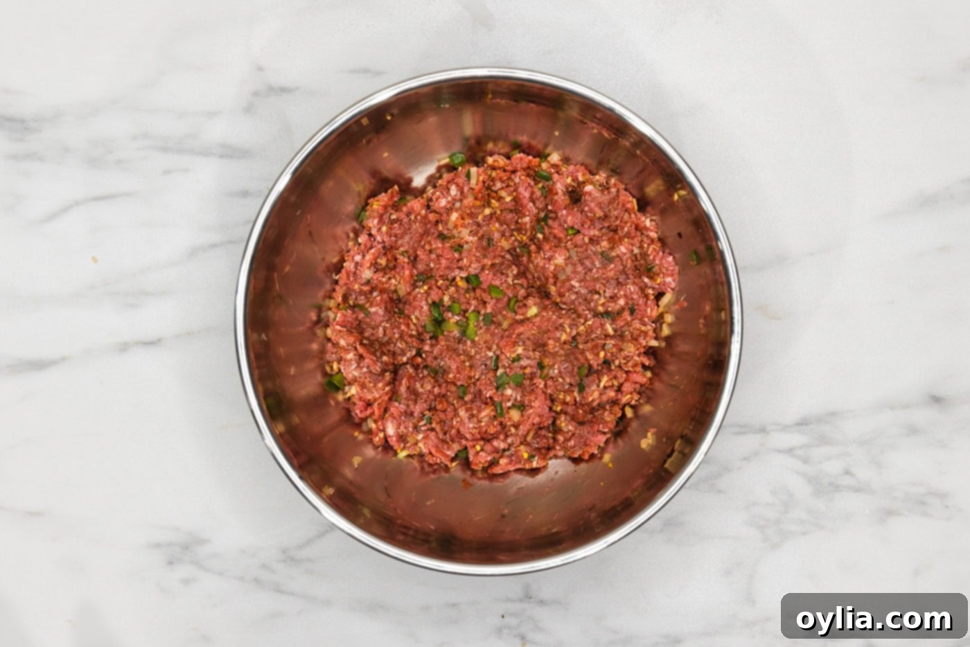 ground beef with diced jalapenos and onions in a bowl