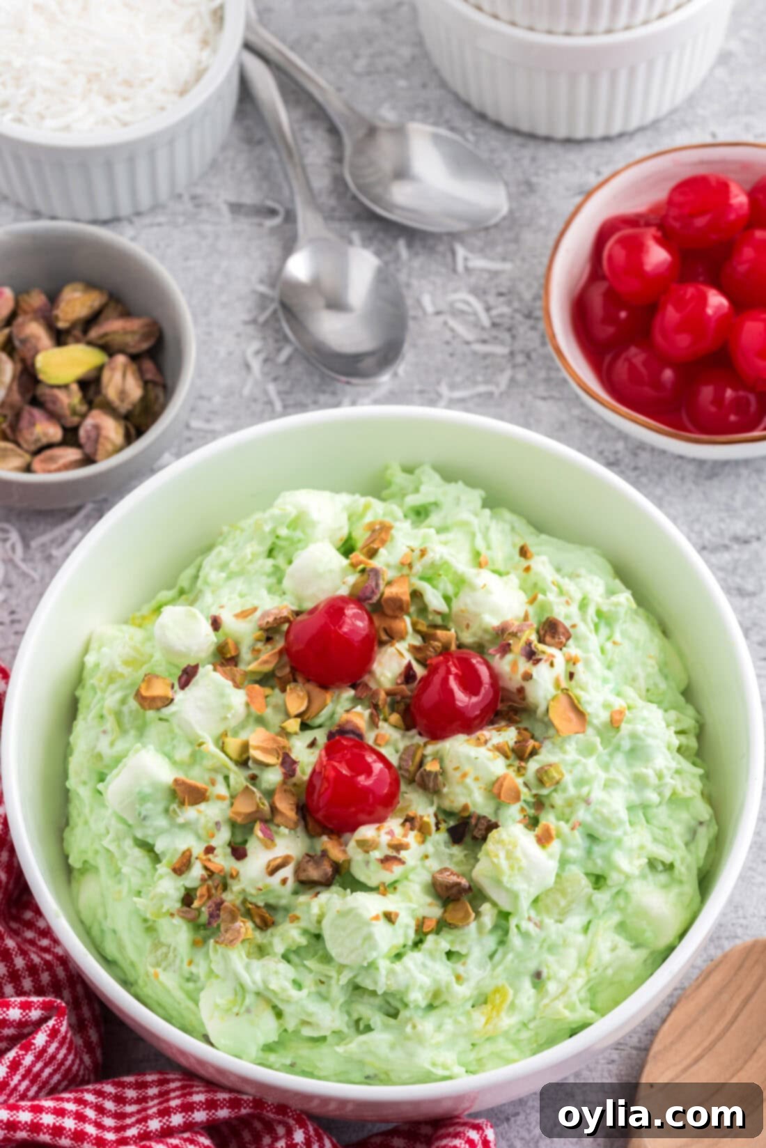 A large glass bowl overflowing with fluffy green Watergate Salad, showcasing its delightful texture and marshmallow pieces.