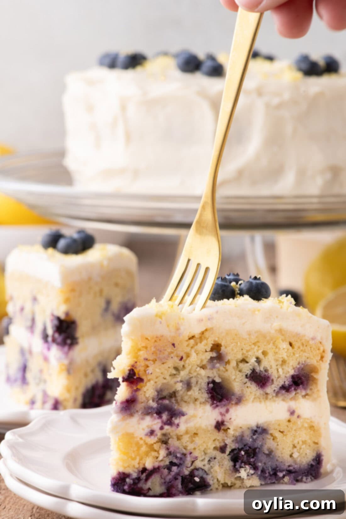 Zesty Lemon Blueberry Bliss 3 Fork going into a slice of Lemon Blueberry Cake