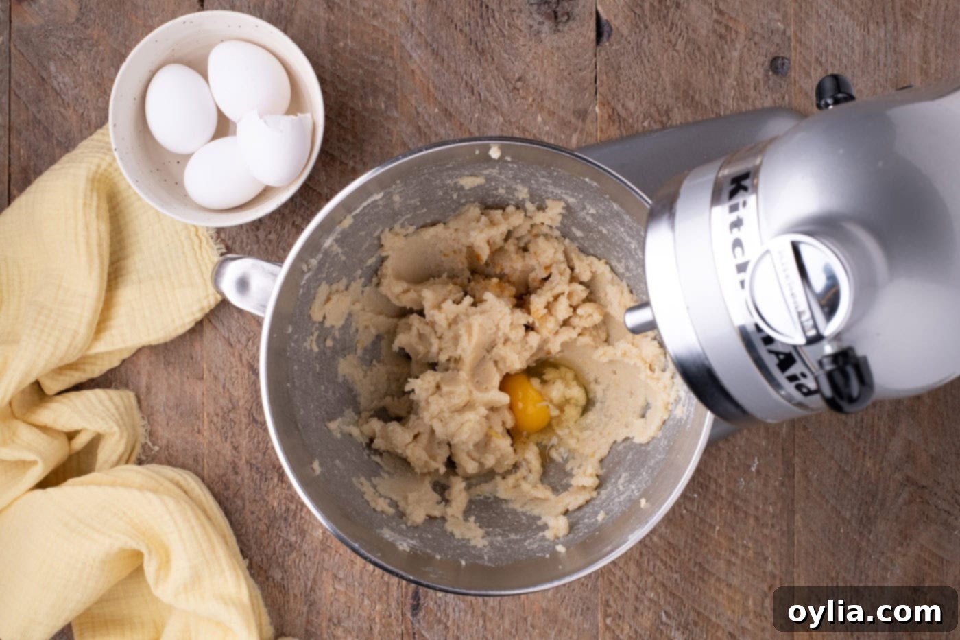 adding eggs to butter and sugar mixture in a mixer
