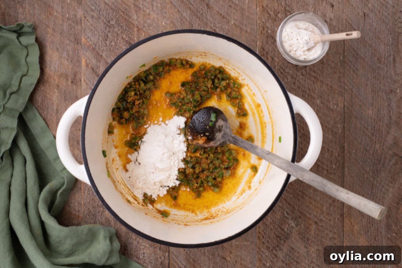 adding spices to pot with jalapenos and butter