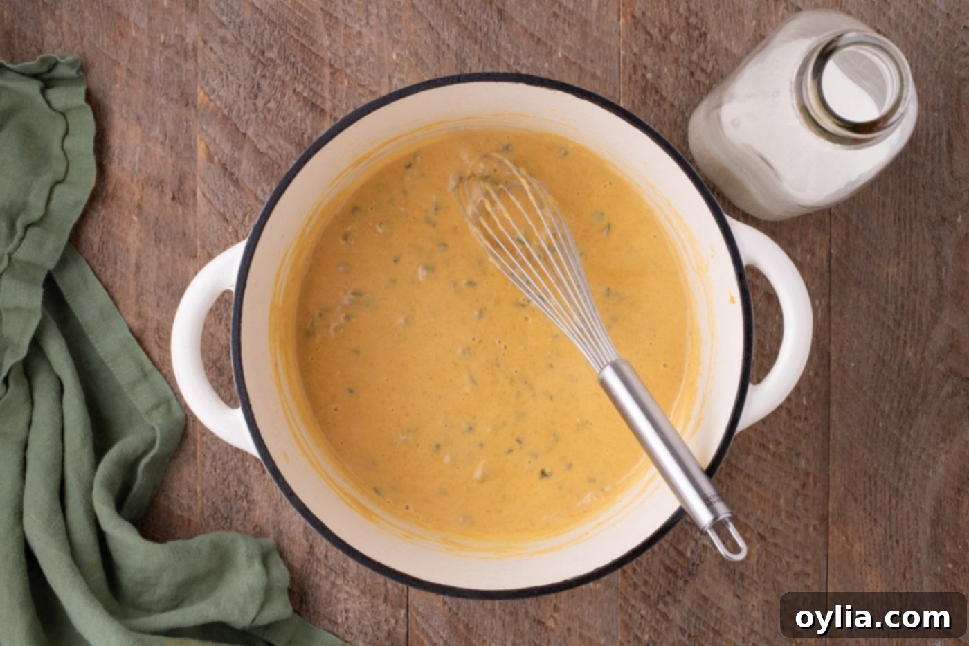 cheese sauce in a pot with a whisk