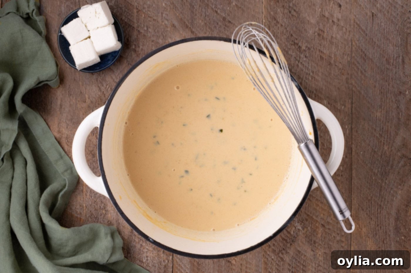 jalapeno cheese sauce in a pan with a whisk