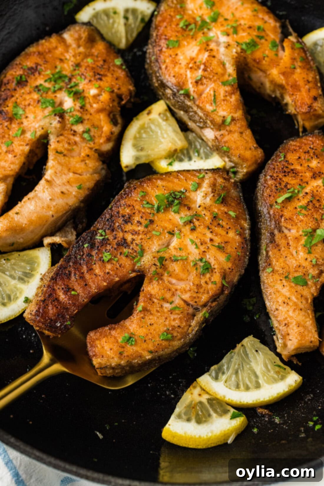 Close up photo of a Salmon Steak on a spatula resting in a skillet