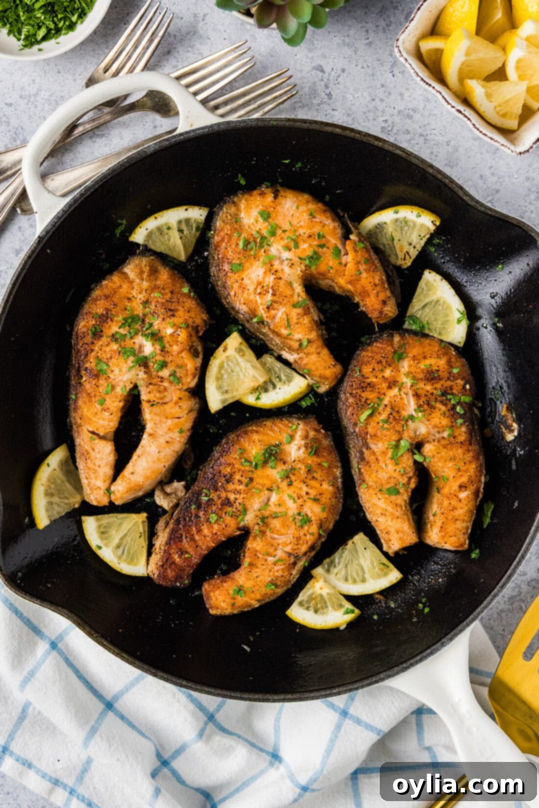 Skillet of Salmon Steaks and lemon wedges