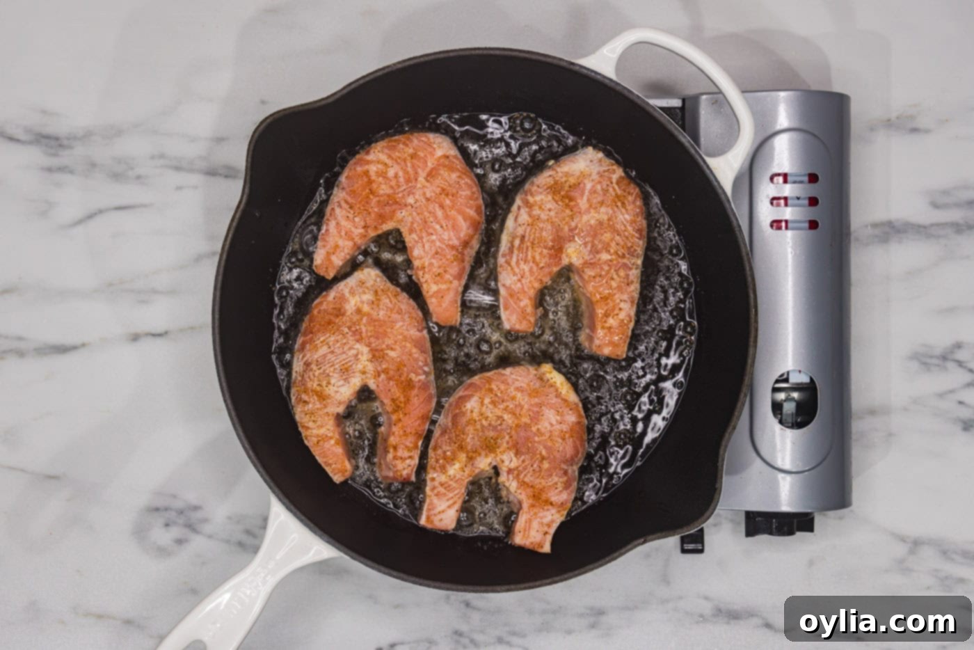 salmon steaks cooking in a skillet