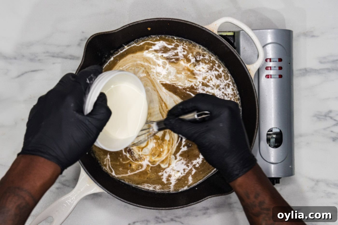 whisking heavy whipping cream into skillet with wine, lemon juice, and chicken base