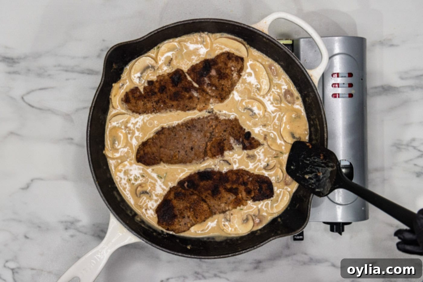 veal cutlets in cream and mushroom sauce in a skillet