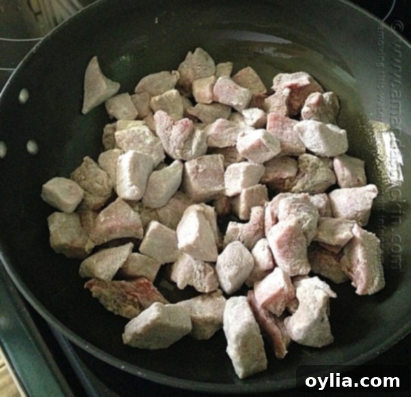 Beef Stew Biscuit Pot Pie - Step 1: Dredging beef stew meat in a flour and spice mixture.
