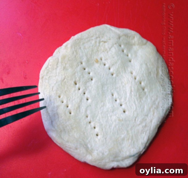 Beef Stew Biscuit Pot Pie - Step 4: Flattening a biscuit with the palm of a hand before placing it on top of the stew.