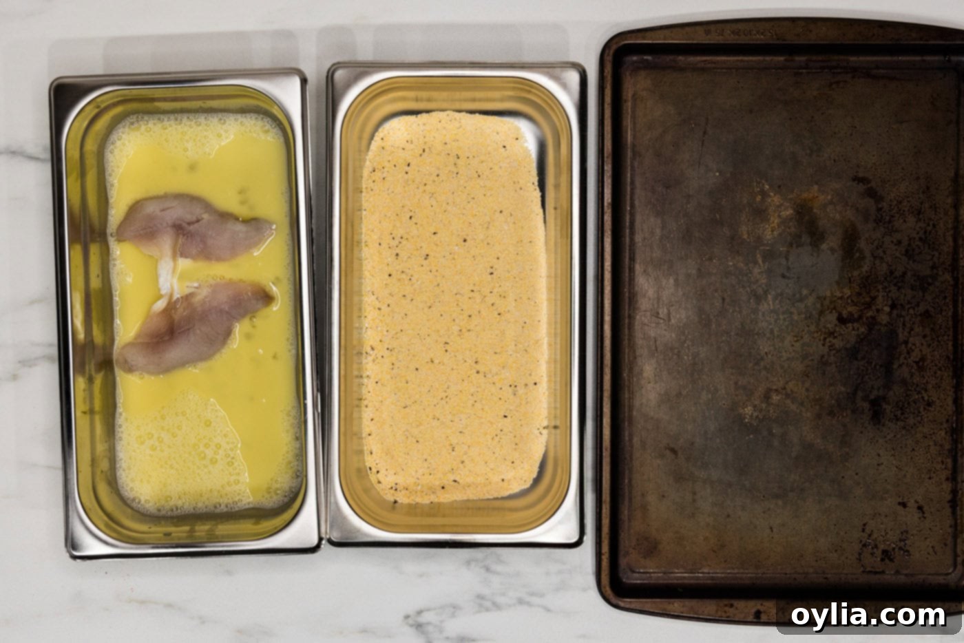 perch filets in egg mixture in a breading tray