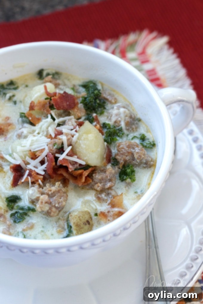 Close up photo bowl of homemade Zuppa Toscana soup, garnished with bacon and cheese